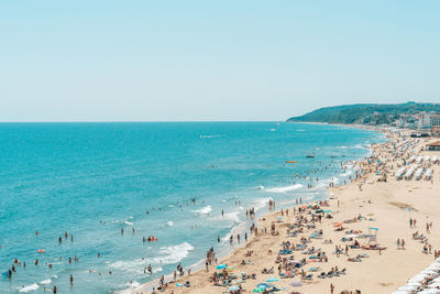 People on beach against clear sky