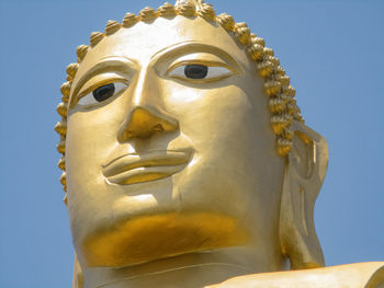 Low angle view of buddha statue against building