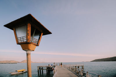 Pier over sea against clear sky during sunset