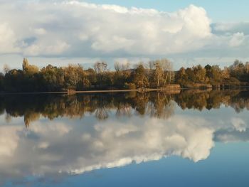 Scenic view of lake by trees against sky