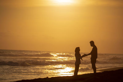 Silhouette warmth on beach during sunset