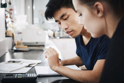 Young university students studying together in classroom