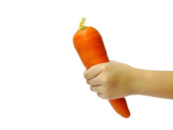 Close-up of hand holding ice cream cone against white background
