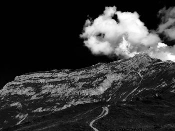 View of rocky mountain against cloudy sky