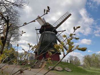 Low angle view of traditional windmill against sky