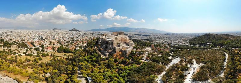 Panoramic view of trees and buildings against sky