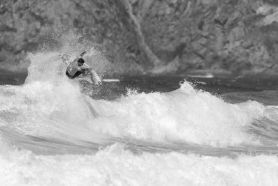 Man surfing in sea against sky