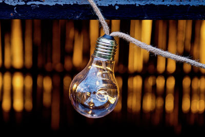 Close-up of light bulb hanging on rope