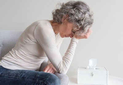 Woman sitting on sofa at home