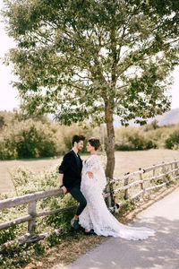 Rear view of couple standing by tree