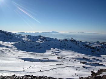 Scenic view of snowcapped mountains against blue sky