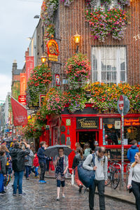 People walking on street against buildings in city