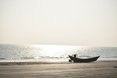 Silhouette boat in sea against clear sky