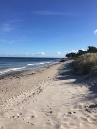 View of sandy beach against blue sky