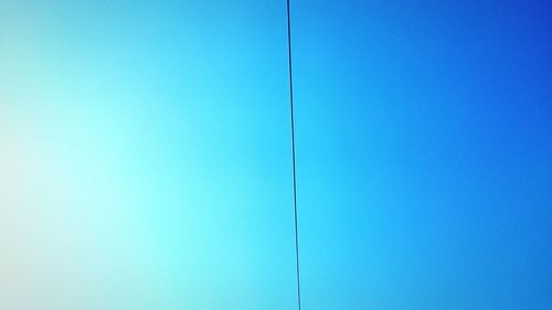 Low angle view of windmill against blue sky