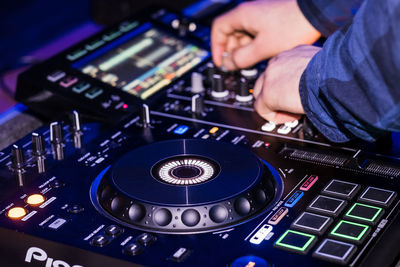 Cropped hands of man playing audio equipment