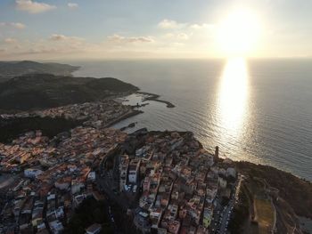 High angle view of townscape by sea against sky during sunset