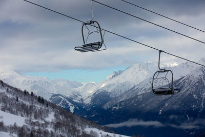 Overhead cable car over snowcapped mountains against sky