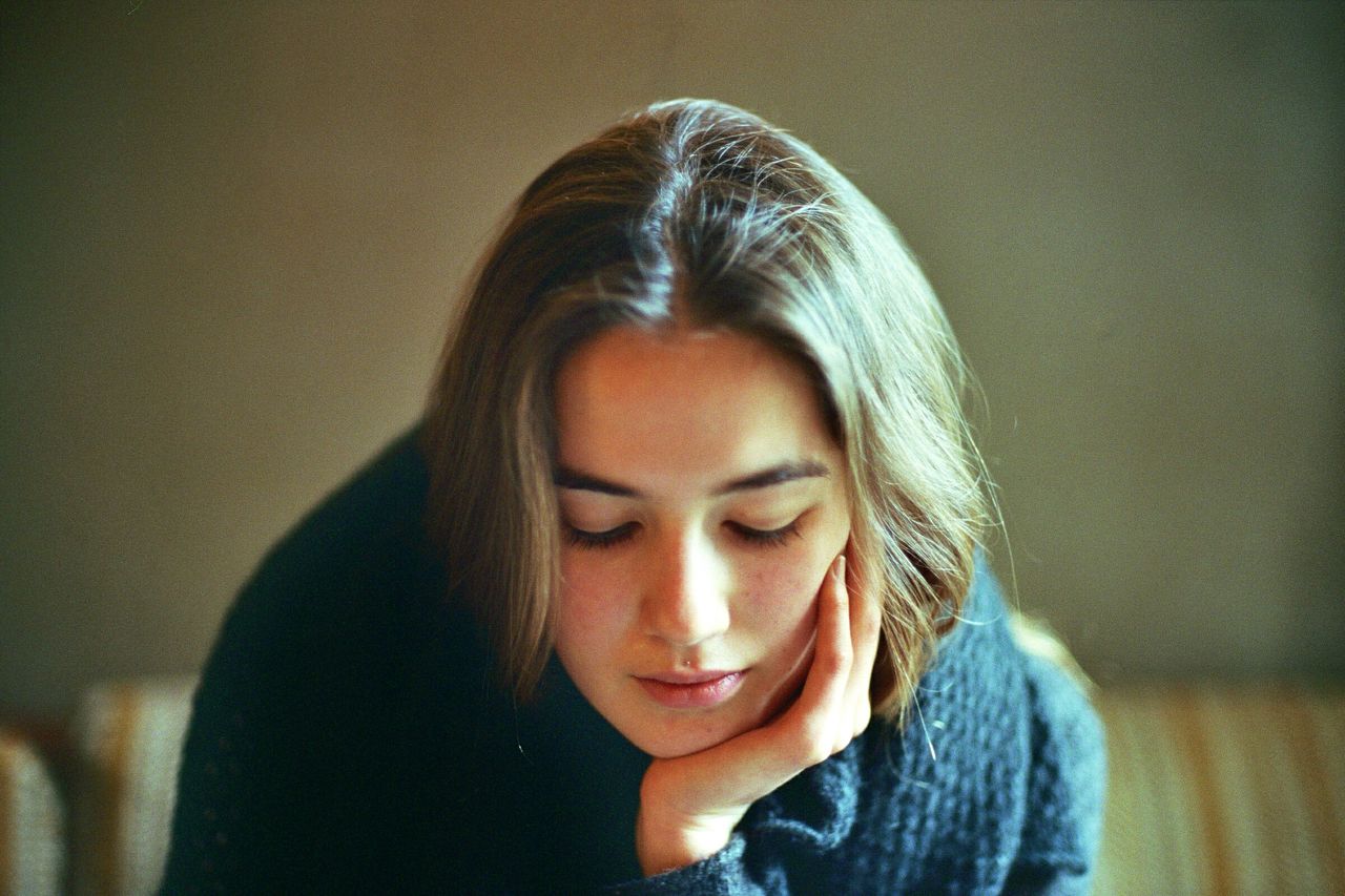 headshot, portrait, looking at camera, young adult, person, front view, lifestyles, close-up, head and shoulders, indoors, contemplation, focus on foreground, serious, young women, human face, leisure activity, casual clothing