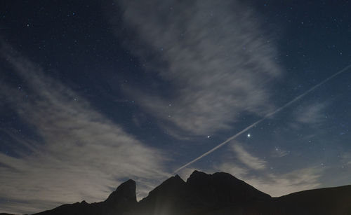 Low angle view of silhouette mountain against sky at night