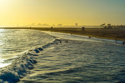 Scenic view of beach against clear sky during sunset