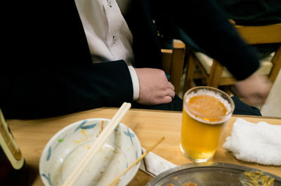 Midsection of man having beer at restaurant