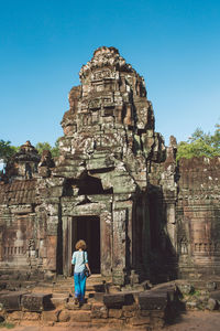 Rear view of woman in temple against sky