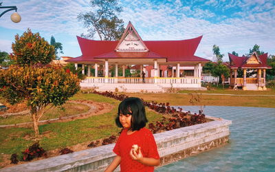 Woman standing by swimming pool against plants