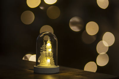 Close-up of illuminated light bulb on table