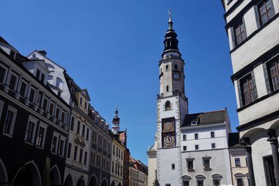 Low angle view of buildings against clear blue sky