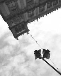 Low angle view of birds on building against sky