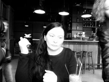 Portrait of young woman sitting in restaurant