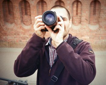 Man photographing with digital camera in old town