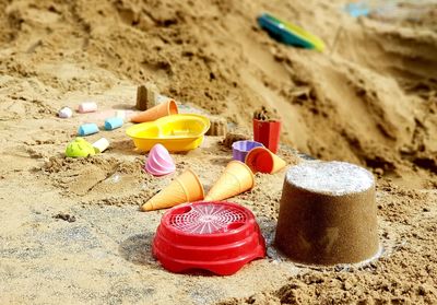 Close-up of toys on sand at beach