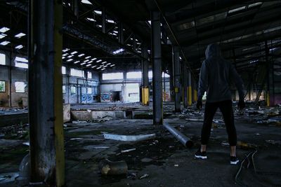 Rear view of man standing in abandoned building