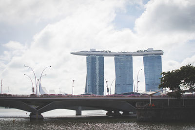 Bridge over river against cloudy sky