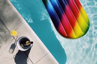 High angle view of swimming pool with champagne bottle 