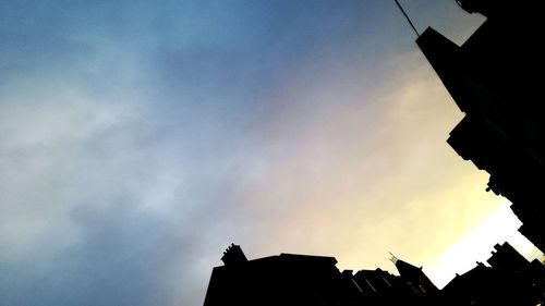 Low angle view of silhouette roof against sky