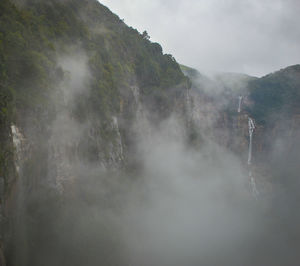 Scenic view of waterfall against sky