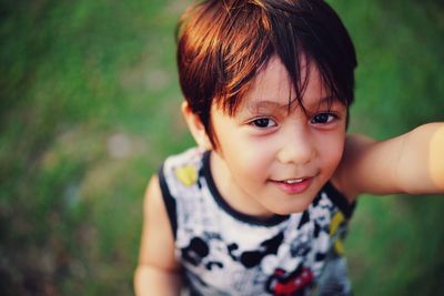 High angle portrait of smiling boy standing on field