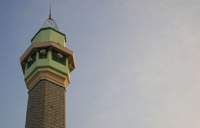 Low angle view of tower and building against sky