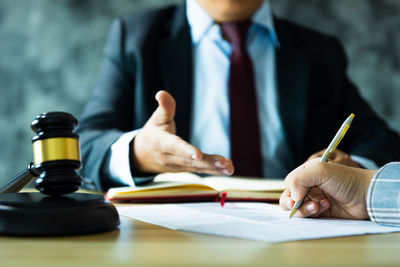 Midsection of lawyer working at table