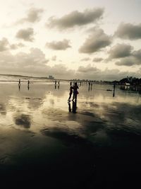 People on beach against sky