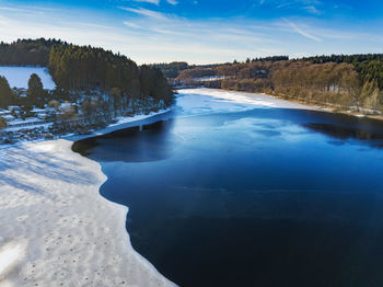 Scenic view of lake against sky during winter