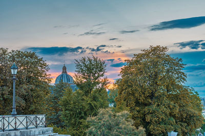 Trees and building against sky during sunset