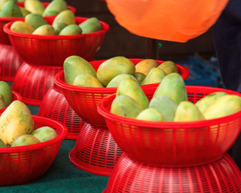 Fresh mangoes in red baskets at the stall.