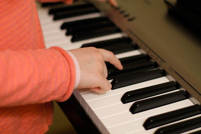 Cropped hands of boy playing piano