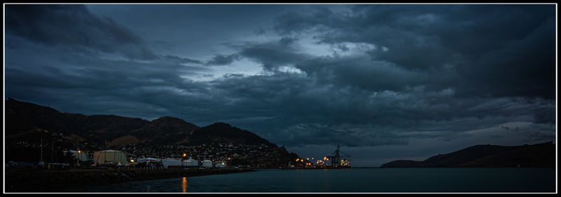 Scenic view of river and mountains against cloudy sky