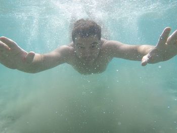 Portrait of young man swimming in sea