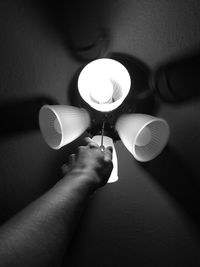 Midsection of person holding illuminated electric lamp